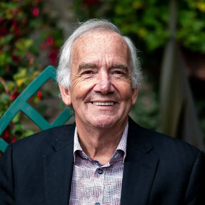 Professor Peter Hawkins, Coacharya board member, smiling in a dark blazer in a garden setting