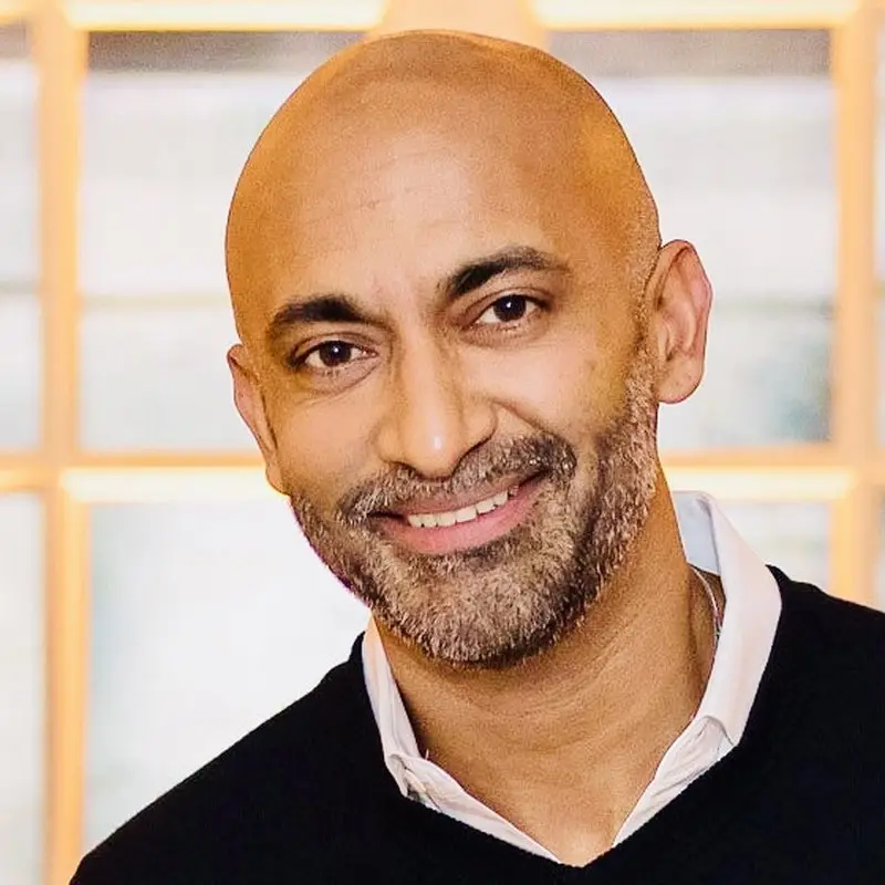 Pranav Ramanathan, CEO and Co-Founder of Coacharya, smiling in a black sweater over a white collared shirt