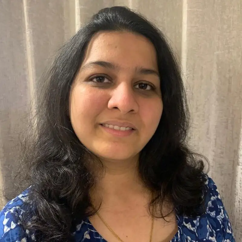 Sweta Barjatya, Coacharya team member, smiling in a blue printed top